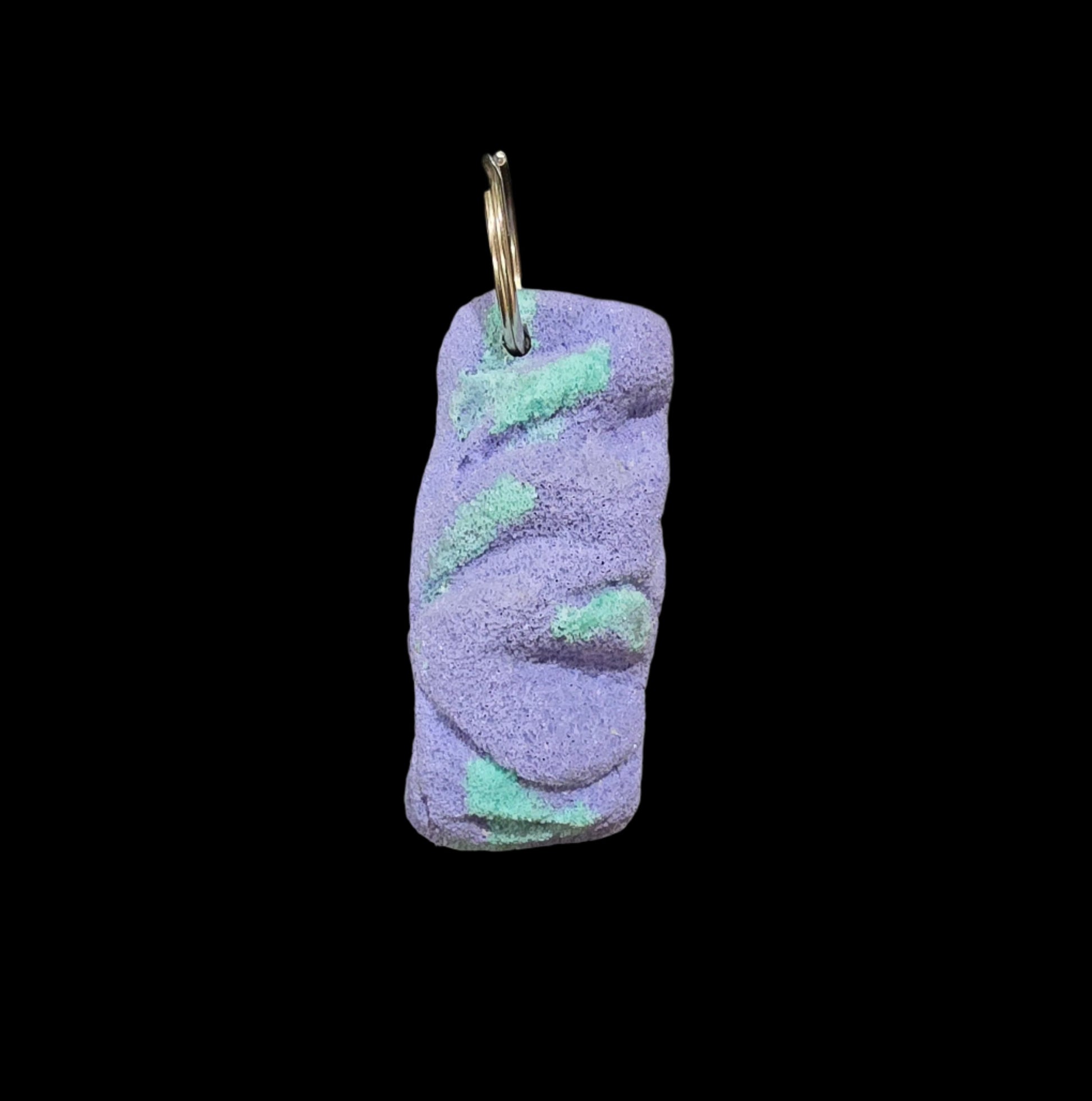 Purple and teal colored eroded shape climbing hold keychain