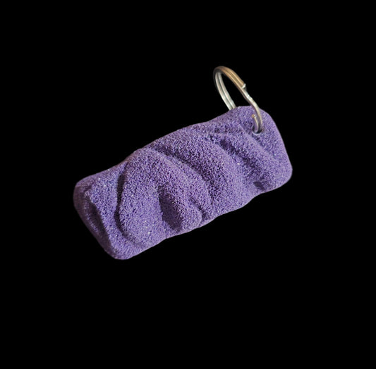 Purple colored eroded shape climbing hold keychain