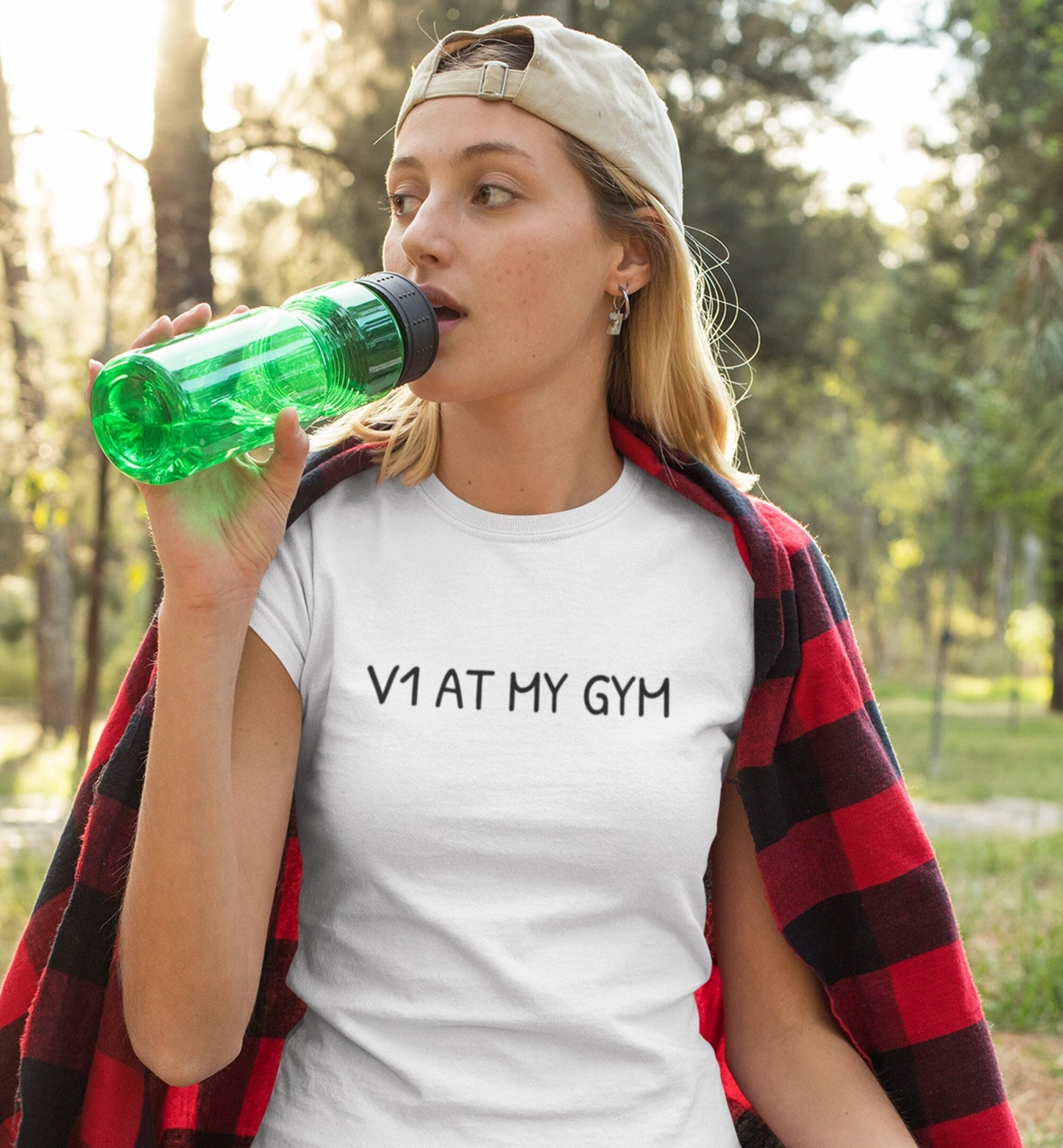 Woman drinking from water bottle while wearing V1 At My Gym climbing shirt